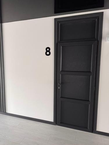 a black door in a room with a wall at Готель WeLKoMe in Krivorovnya