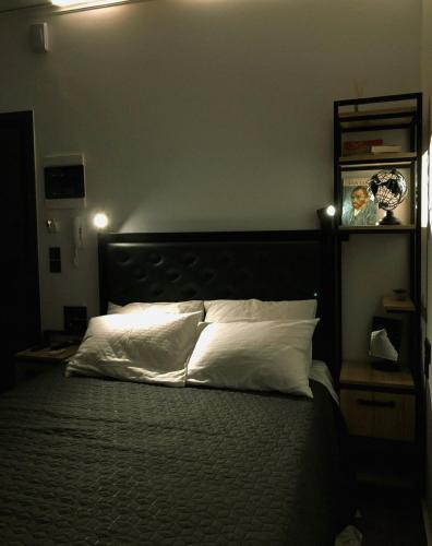 una camera da letto con un grande letto con cuscini bianchi di Studio Mayer a Patra