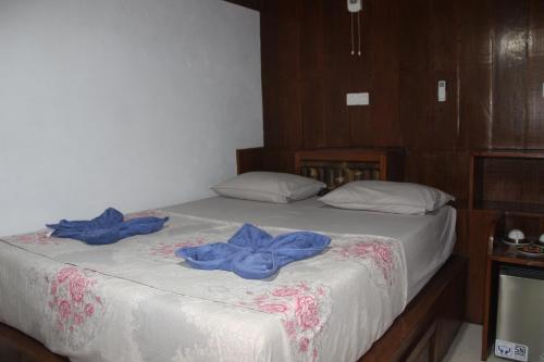 a bedroom with two blue robes on a bed at Sam's Bungalows And Treks in Bukit Lawang
