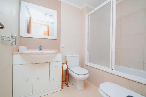 Un baño blanco con inodoro y lavabo. en Blue Sky Denia apartment, en Denia