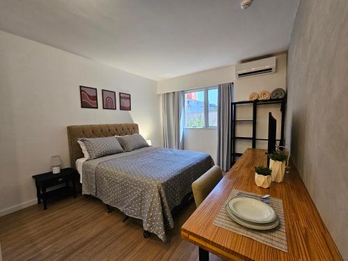 a bedroom with a bed and a table with plates on it at Suíte premium nº 104 no Hotel Metropolitan in Bauru