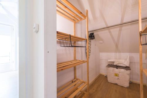 Cozy No 2 Wellness Villa Hottub, Sauna en houtkachel في Hernen: خزانة ملابس مع رفوف خشبية في الغرفة