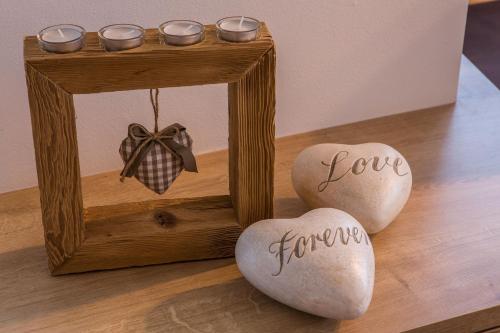 a wooden frame with two hearts with the words love forever at Chalet S Apartments in Campo Tures