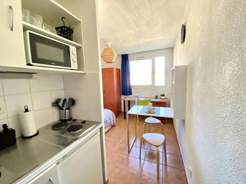 - une cuisine avec deux tabourets et une table dans une pièce dans l'établissement Charmant Studio Moderne Centre & Gare d'Avignon, à Avignon