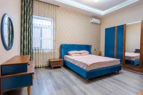a bedroom with a blue bed and a desk at Cozy Retreat Nature & Comfort in Şüvǝlǝn