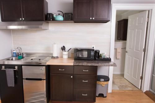 a kitchen with a sink and a microwave on a counter at Knotty Pine Motel in Bennington