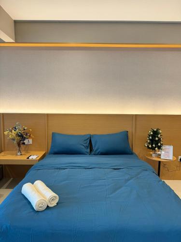 a blue bed with two towels on top of it at Cozy suite-The Shore in Kota Kinabalu