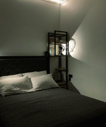 una camera da letto con un letto con lenzuola bianche e uno scaffale di Studio Mayer a Patra