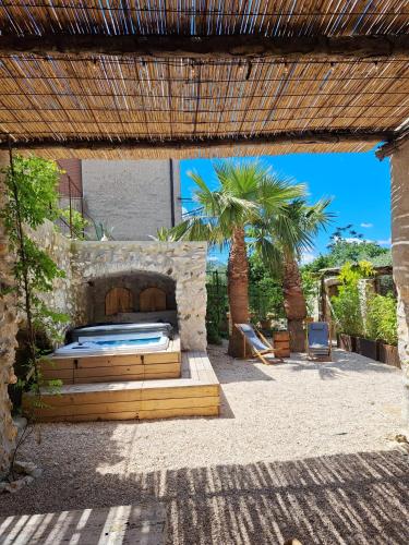 a patio with a bed and a palm tree at Massaria Bove in Cervino