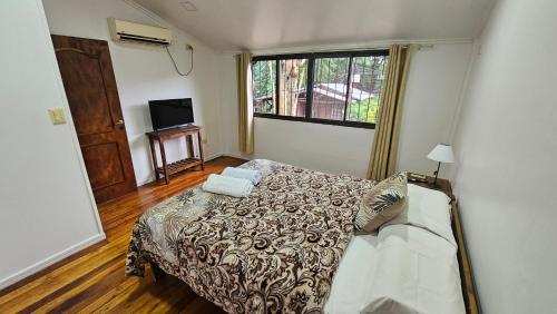 een slaapkamer met een bed, een bank en een raam bij Cómodo Dúplex en Puerto Iguazú in Puerto Iguazú