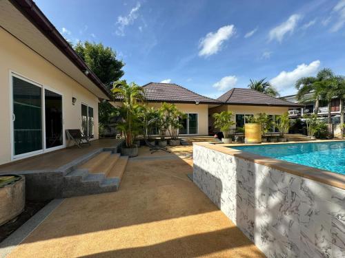 a home with a swimming pool and a house at Thip Siam Village in Ao Nam Mao
