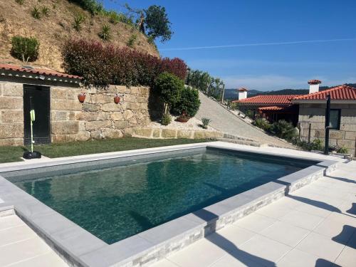 a swimming pool in front of a house at CRASTO PAYVA DOURO NATURE in Castelo de Paiva