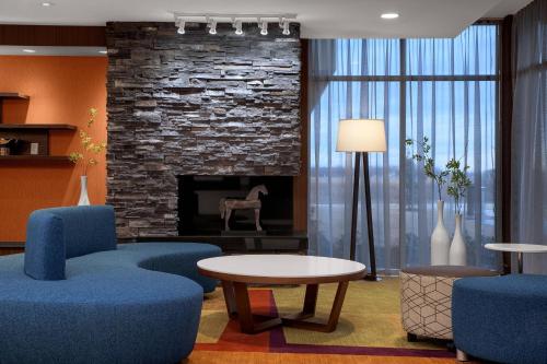 a living room with blue chairs and a fireplace at Fairfield Inn & Suites by Marriott Memphis Marion, AR in Marion
