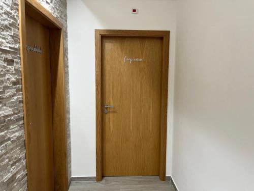 a hallway with two wooden doors and a brick wall at CRASTO PAYVA DOURO NATURE in Castelo de Paiva
