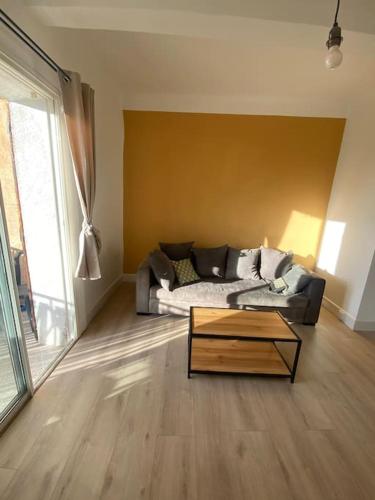 un salon avec un canapé et une table basse dans l'établissement Appartement lumineux et calme, à Éguilles