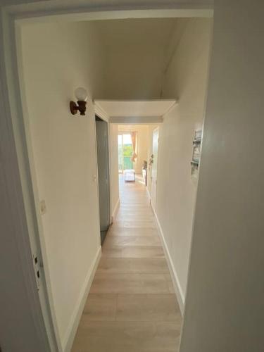 un couloir avec des murs blancs et un long couloir avec dans l'établissement Appartement lumineux et calme, à Éguilles