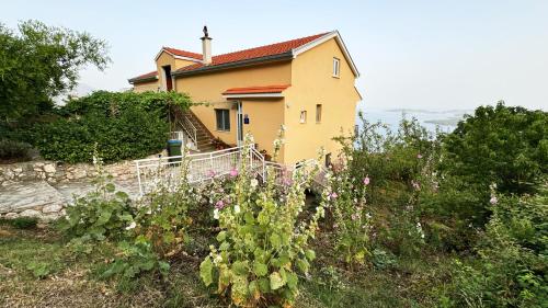 a house on a hill with flowers in front of it at Apartman Dani in Orebić
