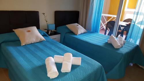 Habitación con 2 camas y toallas. en Residencial Cotillo Playa, en Cotillo