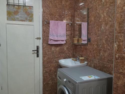 a bathroom with a washing machine and a sink at superbe appartement F3 - 80m2 in Oran