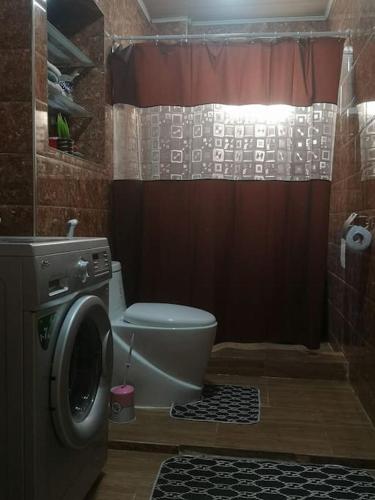 a bathroom with a toilet and a washing machine at superbe appartement F3 - 80m2 in Oran