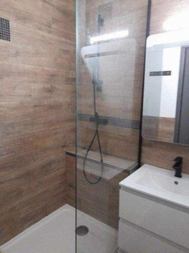 une douche avec une porte vitrée à côté d'un lavabo dans l'établissement Appartement au cœur de la Marina, à Sète