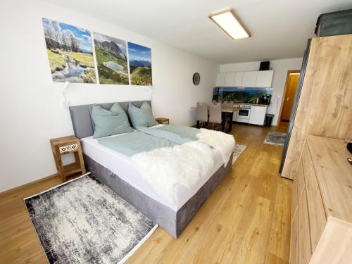 a bedroom with a large bed and a kitchen at 1-Zi-Ferienwohnung Säulingsblick in Oy-Mittelberg