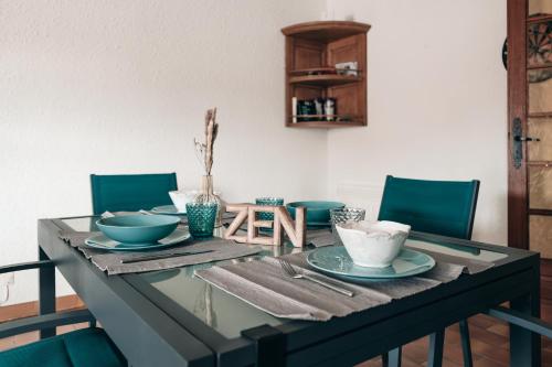 a dining room table with bowls and plates on it at Villa Terra Mera piscine privée proche de Narbonne in Cuxac-dʼAude