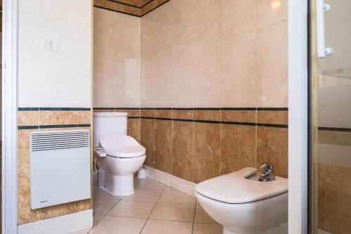 a bathroom with a toilet and a sink at Villa Terra Mera piscine privée proche de Narbonne in Cuxac-dʼAude