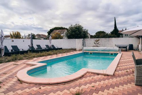 a swimming pool with a table and chairs in a backyard at Villa Terra Mera piscine privée proche de Narbonne in Cuxac-dʼAude