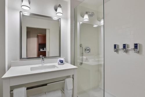 a white bathroom with a sink and a shower at Four Points by Sheraton Dallas Fort Worth Airport North in Coppell