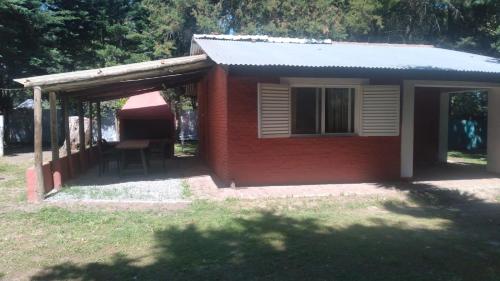una pequeña casa roja con una mesa y una ventana en La casa de Susana en el candil, en Solís