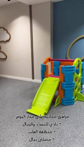 a playground with a green slide in a room at دار المشاعر in Makkah