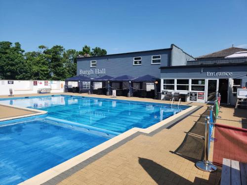a large swimming pool in front of a building at Meadow Crest in Great Yarmouth
