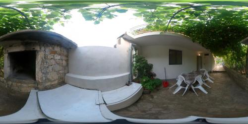 a building with a brick oven in a yard at Apartman Dani in Orebić