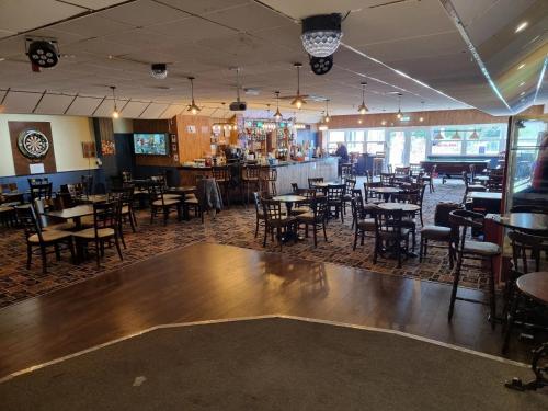 a restaurant with tables and chairs and a bar at Meadow Crest in Great Yarmouth