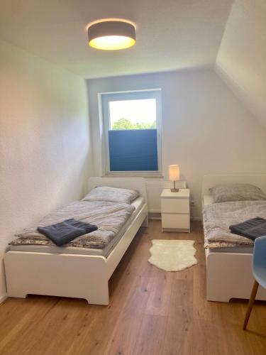 a bedroom with two beds and a window at Ferienwohnung Wiesenglück in Burg Kauper