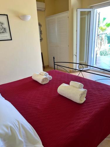 two towels on a red bed in a room at Oasi Di Casablanca in Lampedusa