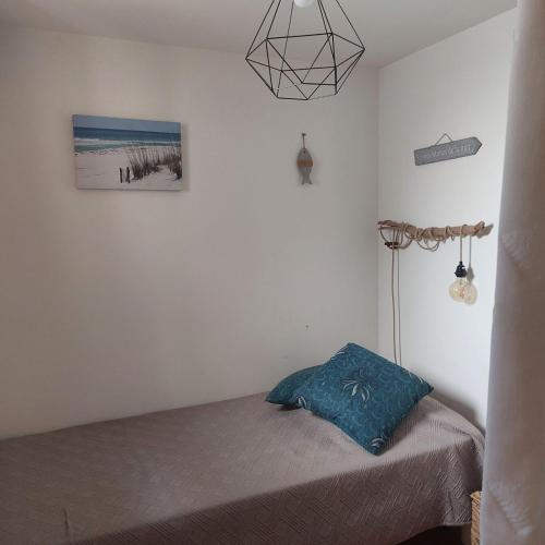 une chambre avec un lit avec un oreiller bleu dessus dans l'établissement Le Balcon des Flots, à Saintes-Maries-de-la-Mer