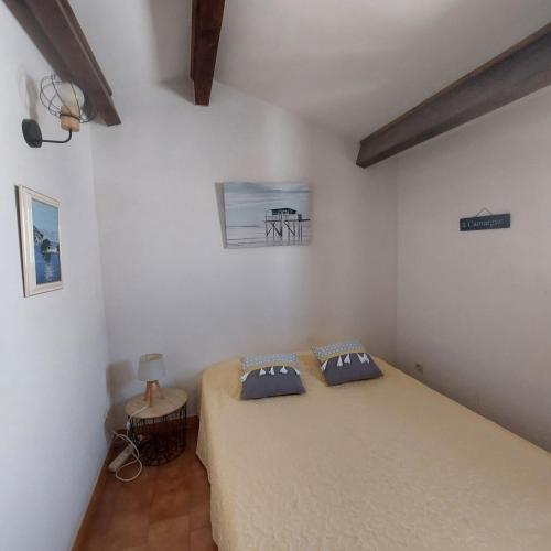 une chambre avec un lit avec deux oreillers dessus dans l'établissement Le Balcon des Flots, à Saintes-Maries-de-la-Mer