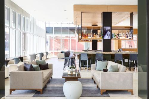 a lobby with couches and a bar in the background at AC Hotel by Marriott Oklahoma City Bricktown in Oklahoma City