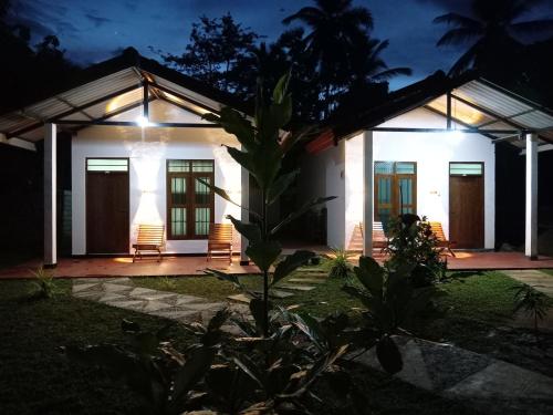 a house with a lit up facade at night at TESHI SAFARI VILLA in Udawalawe