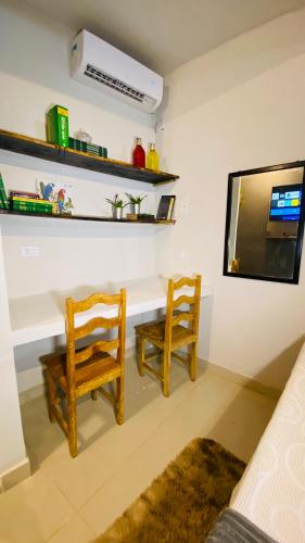 a living room with two chairs and a tv at Studio Terra Nova in Itumbiara