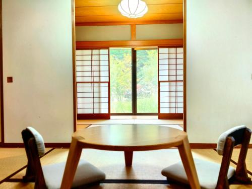a room with a table and chairs and windows at Solvana FUJIKAWAGUCHIKO in Fujikawaguchiko