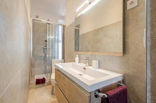 une salle de bain avec un lavabo blanc et une douche dans l'établissement Cannes, charmant 3 pièces proche centre et plages, à Cannes