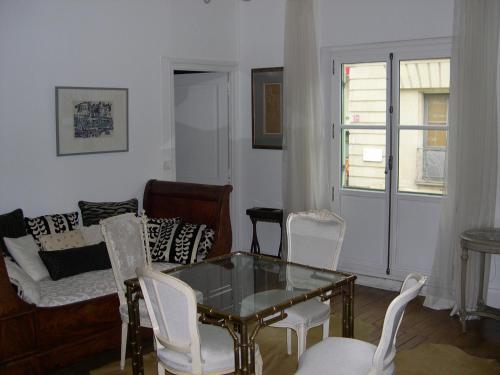 - un salon avec une table en verre et des chaises blanches dans l'établissement Ame de Ville, à Angers