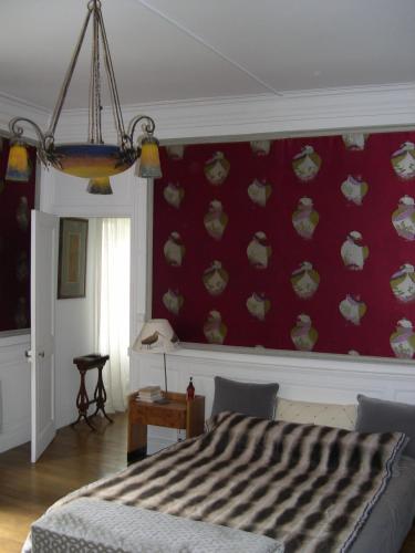 une chambre avec un lit et un mur rouge dans l'établissement Ame de Ville, à Angers