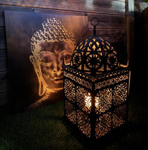 a lantern and a painting of a head on a wall at Gîte Studio Alsa 15 avec Jacuzzi privatif in Fortschwihr