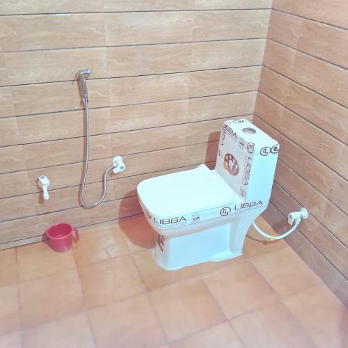 a bathroom with a toilet in a wooden wall at Osian Camel safari and Village home stay in Gheura