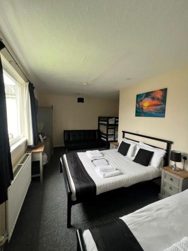a hotel room with two beds and a couch at Burlington Hotel in Sandown