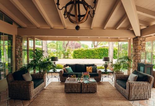 a screened porch with couches and a chandelier at Park Residence Il Gabbiano in Moniga